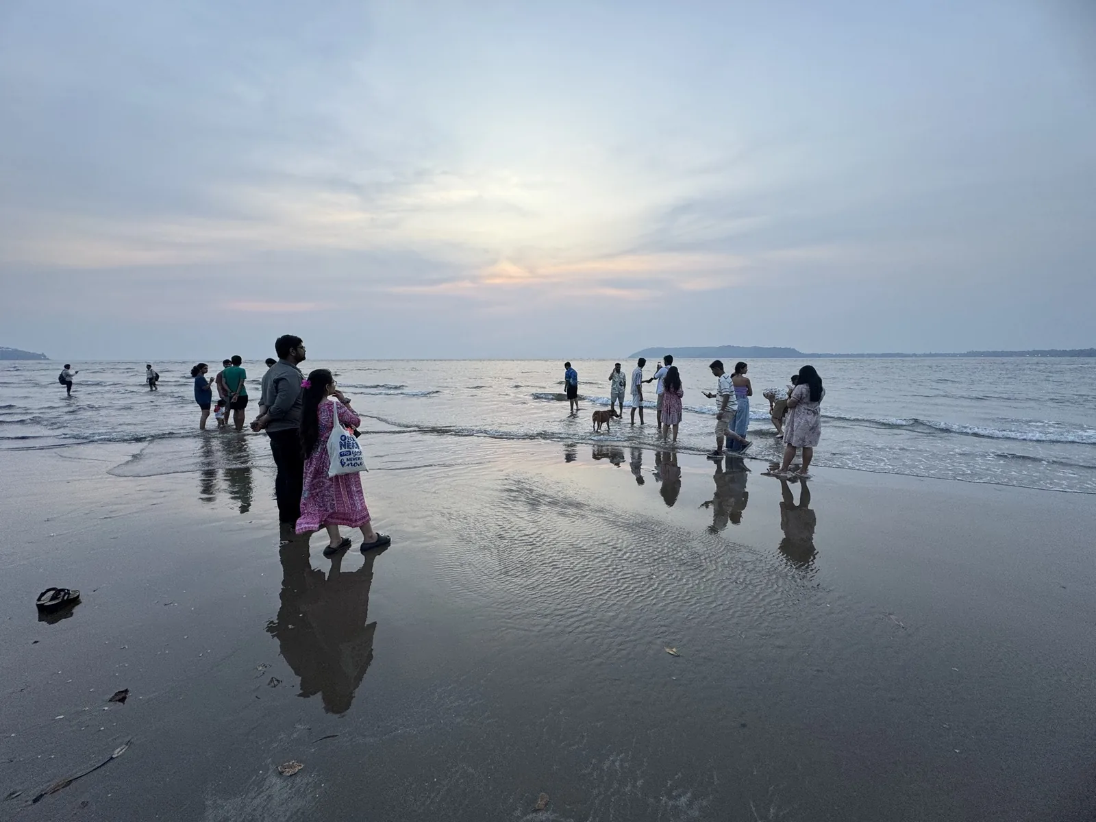 Colleagues relaxing along the shoreline in Goa at sunset
