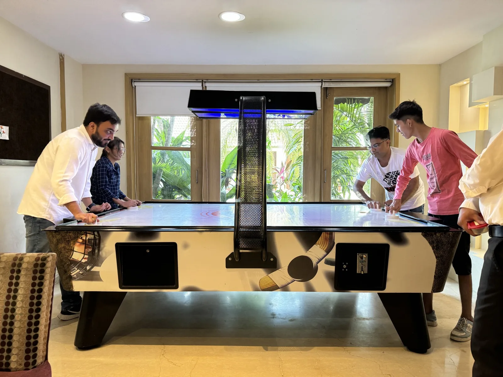 Sharedpro colleagues playing air hockey together during the Madhubhan offsite