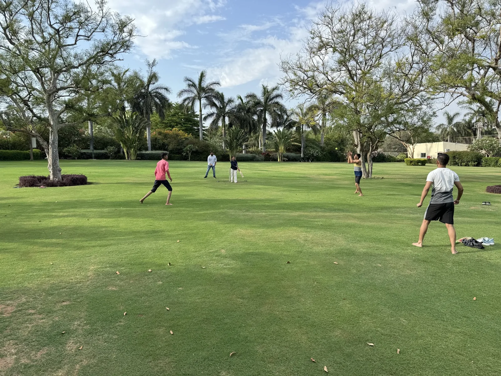 Sharedpro colleagues playing cricket on the lawn during the Madhubhan offsite