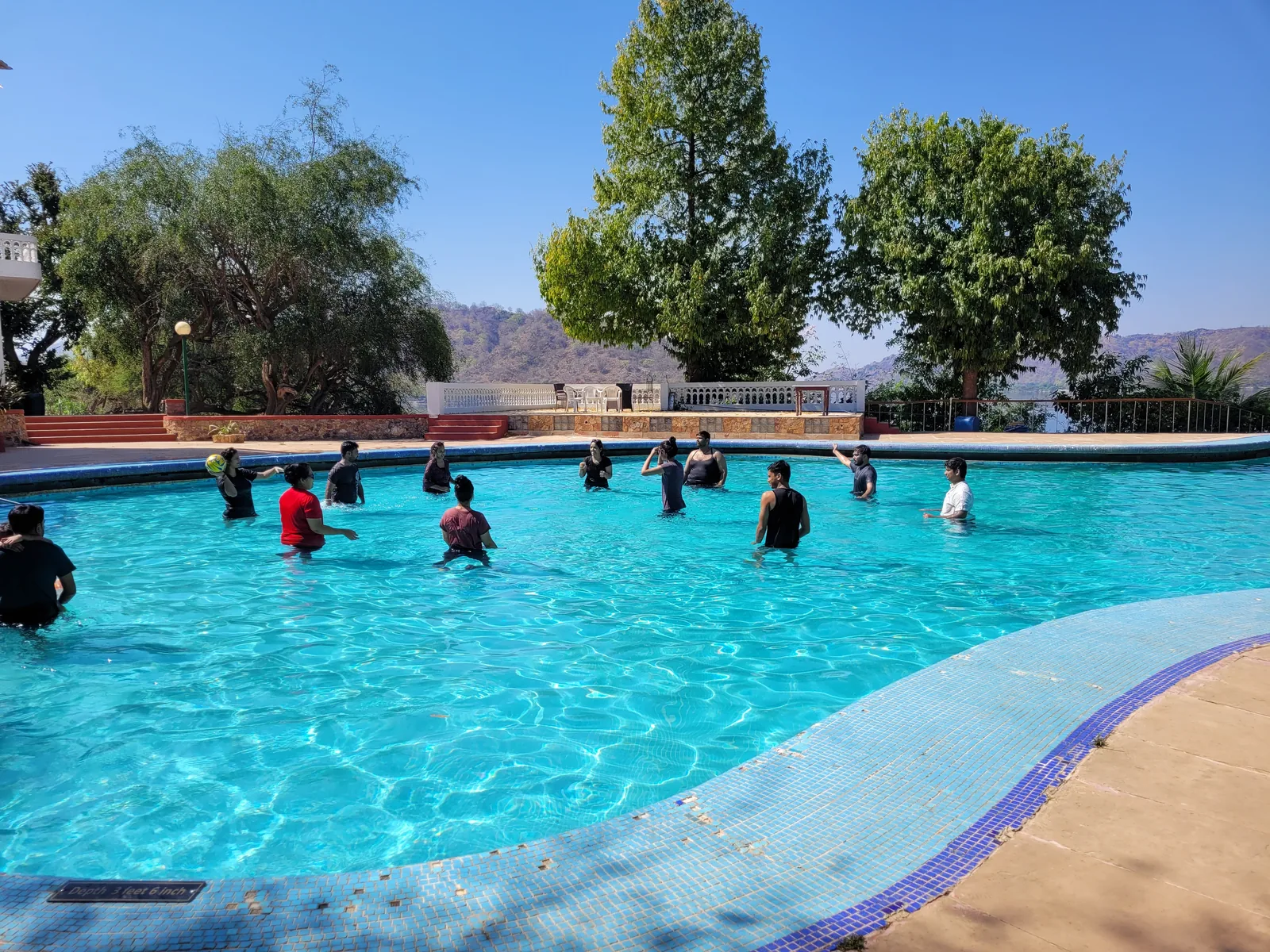 The Sharedpro team playing a ball game in a swimming pool at the Udaipur offsite